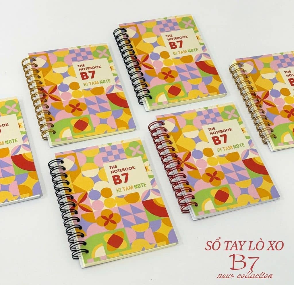 Spiraalgebonden notitieboekje naast laptop en kop koffie